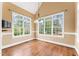 Sunlit breakfast room with large windows, hardwood floors, and neutral paint colors at 100 Tavernelle Pl, Cary, NC 27519