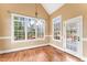 Bright dining area featuring hardwood floors, neutral paint, and large windows overlooking the green yard at 100 Tavernelle Pl, Cary, NC 27519