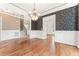 Formal dining room with chandelier, wainscoting, wallpaper, and entryway to another room at 100 Tavernelle Pl, Cary, NC 27519