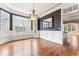 Formal dining room featuring dark wallpaper, large windows, chandelier, and hardwood floors at 100 Tavernelle Pl, Cary, NC 27519