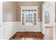 Welcoming entryway with a white door and sidelights, complemented by rich hardwood floors and bright wainscoting at 100 Tavernelle Pl, Cary, NC 27519