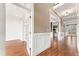 Elegant foyer with hardwood floors, white wainscoting, and doorway leading to a room with built-in shelves at 100 Tavernelle Pl, Cary, NC 27519