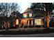 Striking front exterior view of a two-story home, illuminated at dusk with landscape lighting at 100 Tavernelle Pl, Cary, NC 27519