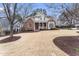 Charming brick home featuring a manicured lawn, mature trees, and a welcoming front porch at 100 Tavernelle Pl, Cary, NC 27519