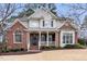 Charming two-story brick home with a covered front porch and manicured landscaping at 100 Tavernelle Pl, Cary, NC 27519
