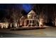 Beautiful two-story home with landscape lighting and manicured lawn at night at 100 Tavernelle Pl, Cary, NC 27519