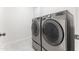 Modern laundry area equipped with stainless steel, front-load washer and dryer at 100 Tavernelle Pl, Cary, NC 27519