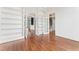 Spacious living room with hardwood floors, built-in shelves, and multiple doorways to other rooms at 100 Tavernelle Pl, Cary, NC 27519