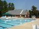 Resort-style community pool with lounge chairs, picnic tables, and a clubhouse for residents' relaxation and entertainment at 100 Tavernelle Pl, Cary, NC 27519