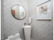 Stylish powder room featuring unique pedestal sink, round mirror, and modern wallpaper at 1004 Kings Mill Rd, Chapel Hill, NC 27517