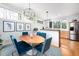 Cozy dining area with modern lighting, blue velvet chairs, and views to the outside deck and kitchen at 1004 Kings Mill Rd, Chapel Hill, NC 27517