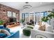 Bright living room with a brick accent wall, large windows, modern lighting and stylish furniture at 1004 Kings Mill Rd, Chapel Hill, NC 27517
