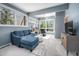 Bright living room with blue sofa, large windows, and contemporary decor at 1004 Kings Mill Rd, Chapel Hill, NC 27517