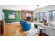 Bright living room with a brick accent wall, large windows, modern lighting and stylish furniture at 1004 Kings Mill Rd, Chapel Hill, NC 27517
