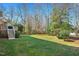 Large grassy backyard with mature trees, a wooden deck, and a fenced perimeter, ideal for outdoor activities at 104 Buckden Pl, Cary, NC 27518