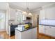 Kitchen island with black granite countertops, stainless steel appliances, and lots of natural light at 104 Buckden Pl, Cary, NC 27518