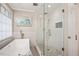 Bright bathroom featuring a soaking tub and glass-enclosed shower at 104 Buckden Pl, Cary, NC 27518