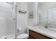 Bathroom with white shower, wood vanity, light marble countertop, and painting on the wall at 104 Red Bark Ct, Apex, NC 27539