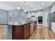 Kitchen featuring a center island, stainless steel appliances, white cabinets, and hardwood flooring at 104 Red Bark Ct, Apex, NC 27539