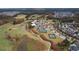 Expansive aerial shot of the community with a golf course, tennis courts, pool, and lush landscaping at 104 Sage Oak Ln, Holly Springs, NC 27540