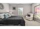 Calm bedroom featuring a large bed with gray bedding and a sitting chair at 104 Sage Oak Ln, Holly Springs, NC 27540