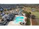 Stunning aerial view of the community pool, clubhouse, tennis courts, and well-kept landscaping at 104 Sage Oak Ln, Holly Springs, NC 27540