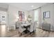 Dining room features a neutral color palette, woven chairs, modern art, and a view to the front entrance at 104 Sage Oak Ln, Holly Springs, NC 27540