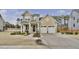 Charming two-story home featuring a covered entryway and a two-car garage with a large concrete driveway at 104 Sage Oak Ln, Holly Springs, NC 27540