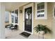 Welcoming front porch featuring a seating area, decorative wreath on the front door, and a 'Welcome Home' doormat at 104 Sage Oak Ln, Holly Springs, NC 27540