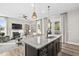 Beautiful kitchen island with granite countertops, pendant lighting, sink, and a view of the living room at 104 Sage Oak Ln, Holly Springs, NC 27540