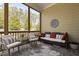 Inviting screened porch featuring comfortable seating and a view of the landscaped backyard at 104 Sage Oak Ln, Holly Springs, NC 27540
