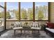 Cozy screened porch with outdoor furniture, offering a relaxing view of nature at 104 Sage Oak Ln, Holly Springs, NC 27540