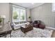 Cozy sitting room features paneled walls, a large window, hardwood floors, and comfortable seating at 104 Sage Oak Ln, Holly Springs, NC 27540