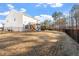 Large, fenced backyard with play set and lush landscaping, perfect for outdoor enjoyment at 106 Capanne Ct, Clayton, NC 27527