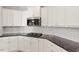 A well-equipped kitchen features white cabinets, stainless steel appliances, and granite countertops at 106 Capanne Ct, Clayton, NC 27527