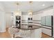 Modern kitchen boasts an island with granite countertops, stylish lighting, and stainless steel appliances at 106 Capanne Ct, Clayton, NC 27527