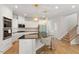Bright kitchen with white cabinetry, stainless appliances, granite countertops, and a cozy breakfast bar at 106 Capanne Ct, Clayton, NC 27527