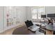 Bright home office featuring french doors, wood floors, and modern desk with computers at 106 Capanne Ct, Clayton, NC 27527