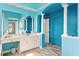 A blue-themed bathroom featuring double vanity, tile floors, and elegant pillars at 108 Finnway Ln, Cary, NC 27519
