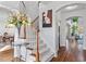 Bright foyer with hardwood floors, staircase, elegant floral arrangement, and decorative artwork at 108 Finnway Ln, Cary, NC 27519