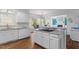 Bright kitchen with white cabinets, granite countertops, hardwood floors, and stainless steel appliances at 108 Finnway Ln, Cary, NC 27519