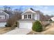 Charming home featuring a two-car garage with stone accents and classic architectural details at 108 Wagon Tie Ln, Garner, NC 27529