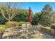 Charming backyard patio with stone surround, brick pavers, and a glass-top table with seating for six at 1109 Frenchurch Way, Apex, NC 27502