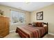 Bright bedroom with a large window, closet, and patterned bedding at 1109 Frenchurch Way, Apex, NC 27502