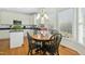 Bright breakfast nook with hardwood floors adjacent to a kitchen with white cabinets at 1109 Frenchurch Way, Apex, NC 27502
