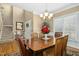 Elegant dining room with wood table, seating for six, and decorative chandelier lighting at 1109 Frenchurch Way, Apex, NC 27502