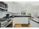 Modern kitchen with stainless steel appliances, granite countertops, and white cabinetry at 1109 Frenchurch Way, Apex, NC 27502