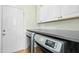 Functional laundry room with modern washer and dryer set and storage cabinetry at 1109 Frenchurch Way, Apex, NC 27502