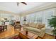 Bright living room featuring hardwood floors, neutral tones, and a view into the kitchen at 1109 Frenchurch Way, Apex, NC 27502