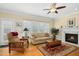 Inviting living room with a fireplace, hardwood floors, and a ceiling fan at 1109 Frenchurch Way, Apex, NC 27502